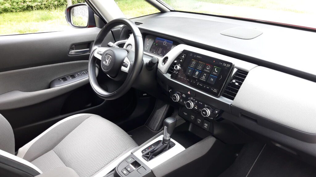 Volič jízdních režimů oproti většímu modelu CR-V Hybrid nesuplují tlačítka, ale je jím hezky do ruky padnoucí klasická páka. (foto Vladimír Löbl)